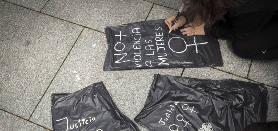 Una joven escribe una pancarta: "No a la violencia contra las mujeres"