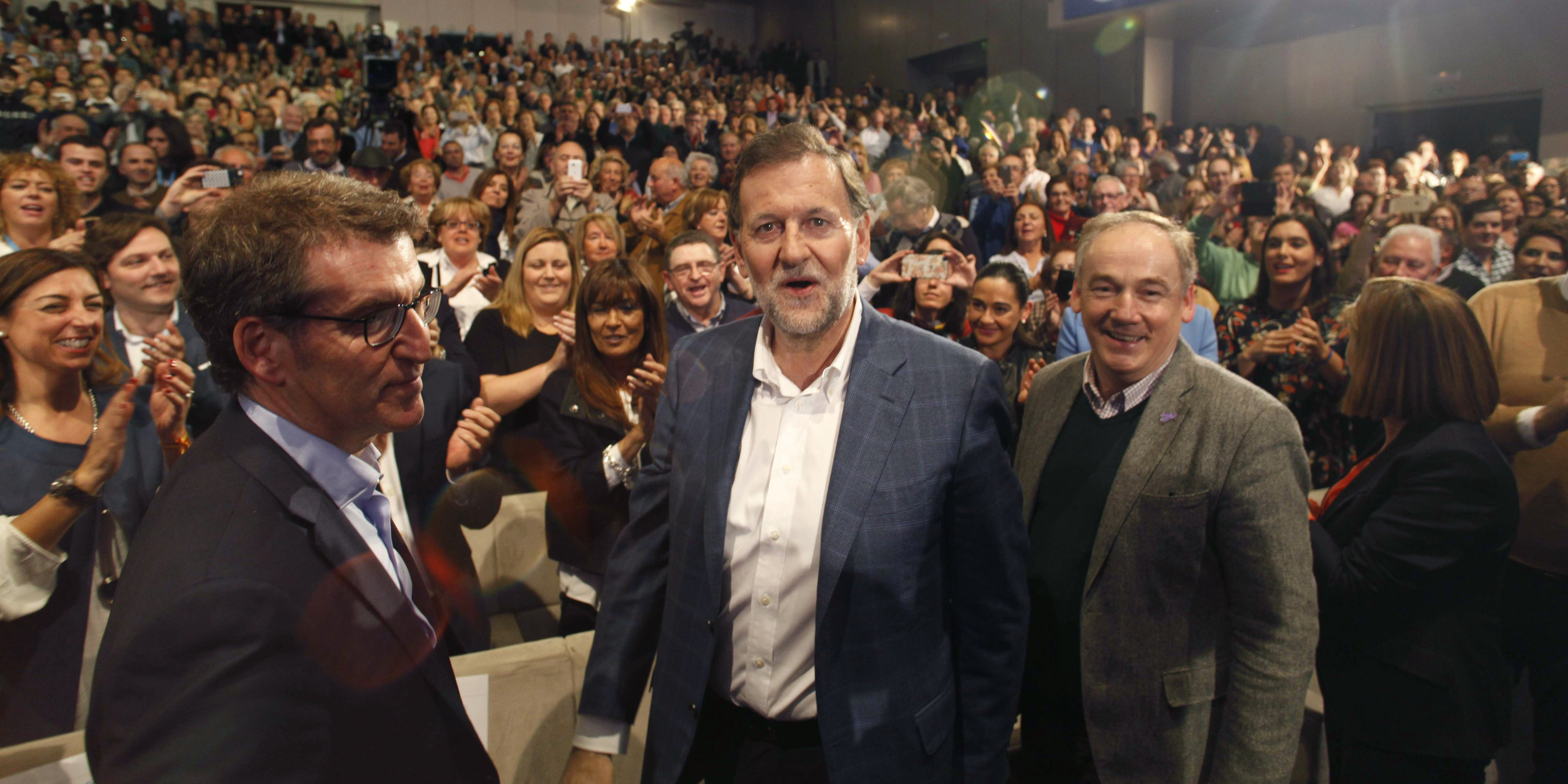 El presidente del Gobierno y candidato a la reelección por el PP, Mariano Rajoy (c), junto al presidente de la Xunta, Alberto Núñez Feijóo (i), al inicio del mitin central de su partido hoy en A Coruña. Rajoy ha llegado al recinto sin gafas tras ser agred