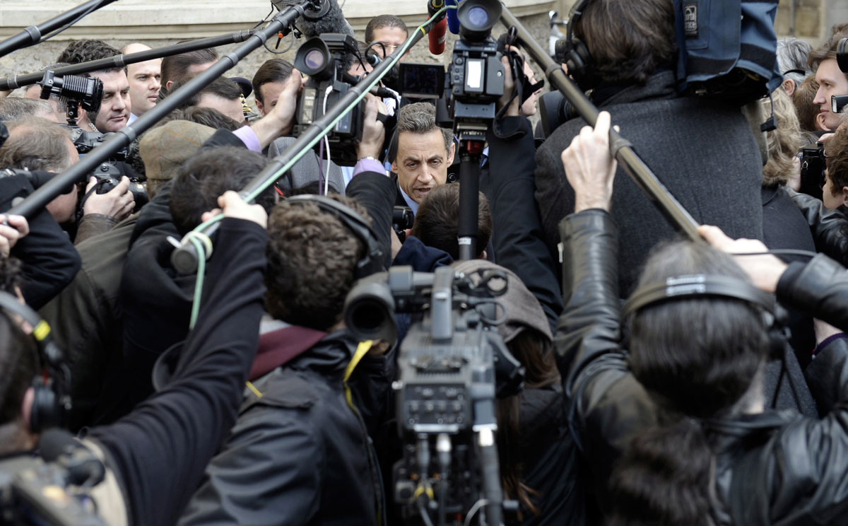 Una nube de periodistas rodea al expresidente francés, Nicolás Sarkozy, en París.