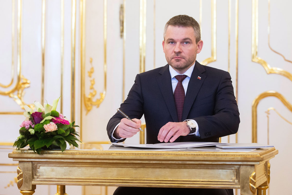 El nuevo primer ministro eslovaco, Peter Pellegrini, firma un documento durante la ceremonia de nombramiento del nuevo Gobierno