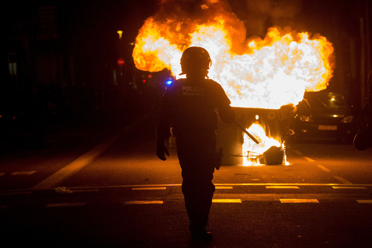 Contenedores ardiendo en los alrededores de la Delegación del Gobierno en Barcelona tras la manifestación convocada esta tarde. EFE