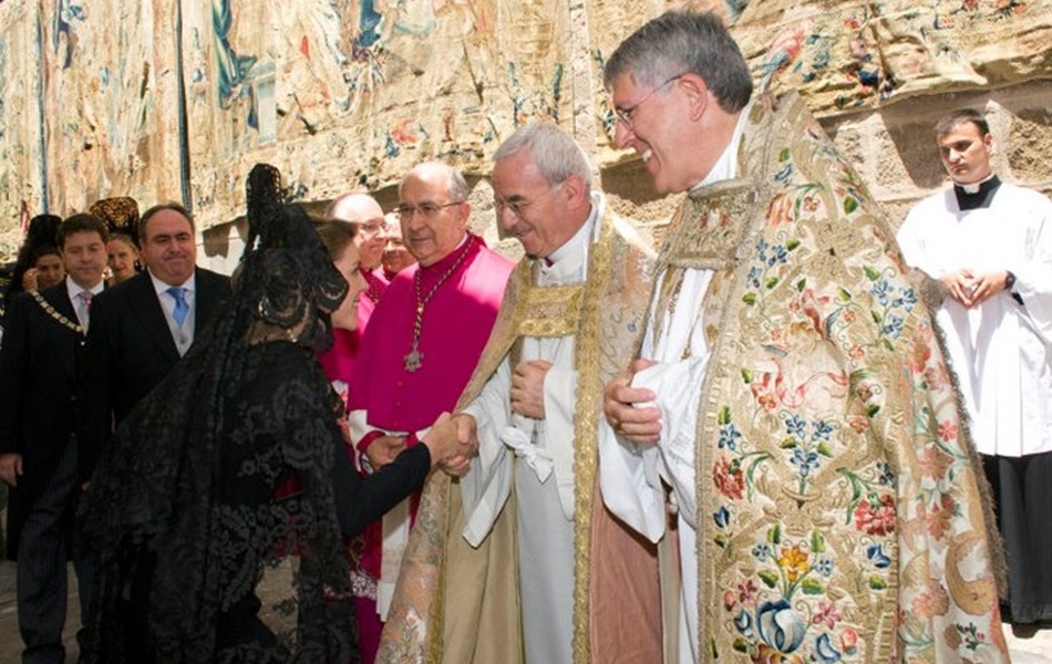 María Dolores de Cospedal hace una reverencia ante el Obispo. 