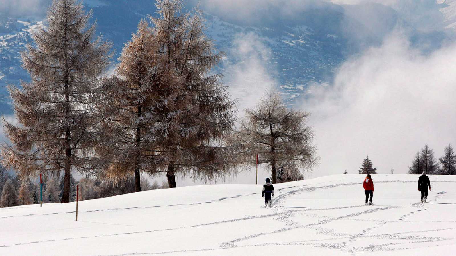 Varias personas caminan por la nieve en Valais, Suiza.