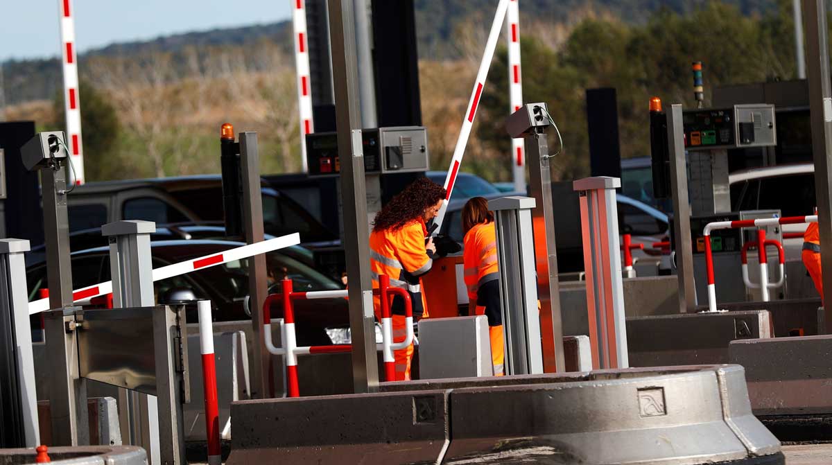 Operarios de autopistas trabajan en poner las barreras del peaje de la autopista AP-7 a la altura de La Roca del Vallès, en dirección Barcelona. 