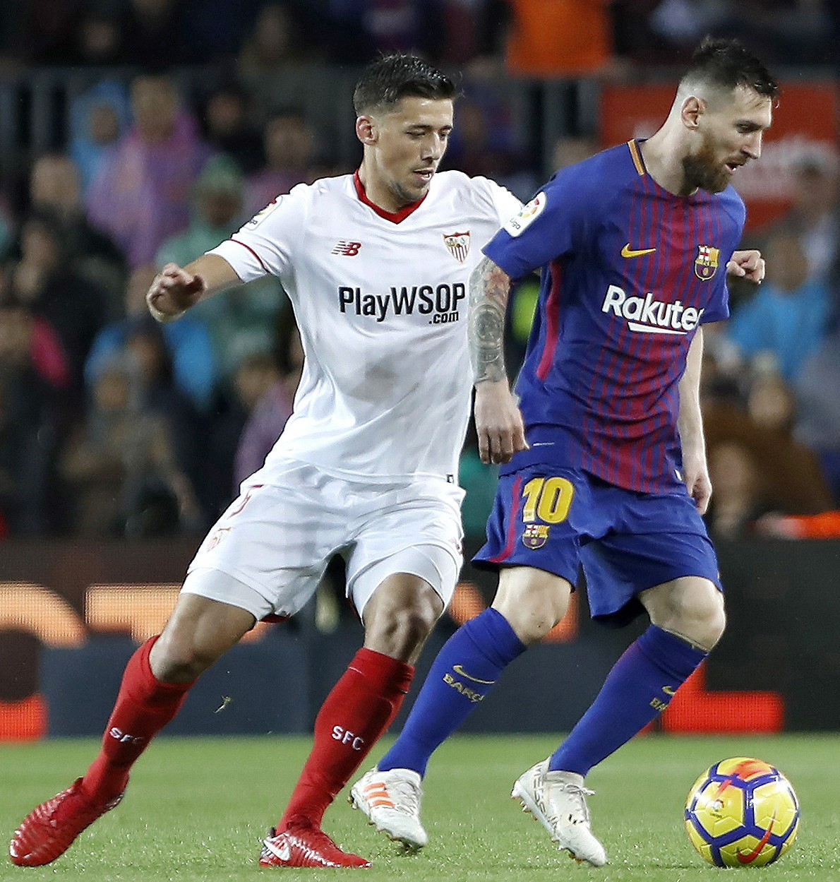 El delantero del FC Barcelona Leo Messi (d) protege el balón ante el francés Clement Lenglet, del Sevilla, durante un partido.