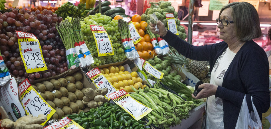En la imagen, una mujer hace su compra en una frutería del mercado Maravilla en Madrid En la imagen, una mujer hace su compra en una frutería del mercado Maravilla en Madrid