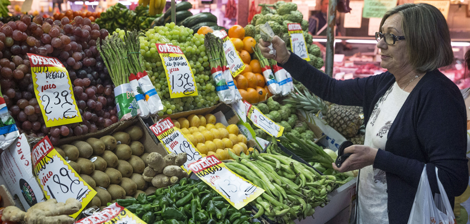 En la imagen, una mujer hace su compra en una frutería del mercado Maravilla en Madrid