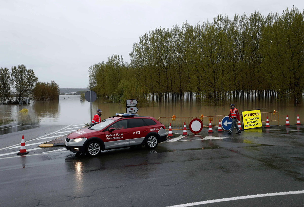 Efectivos de la Policia Foral junto a la N-113 que permanece cortada hacia Castejón tras el desbordamiento del río Ebro. 