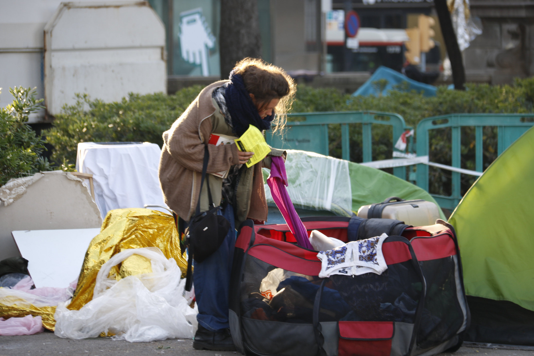 Una mujer recoge sus pertenencias ante el desalojo de la plaza Catalunya de Barcelona.