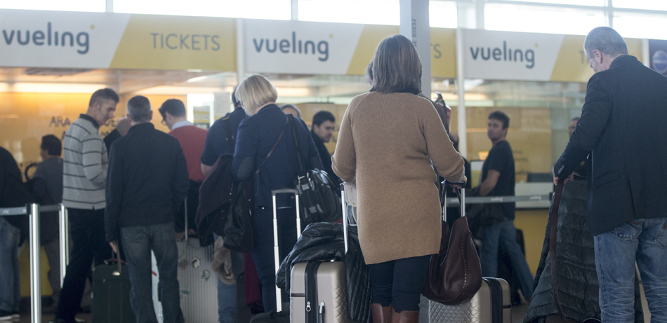 Varios viajeros en los mostradores de la aerolínea Vueling