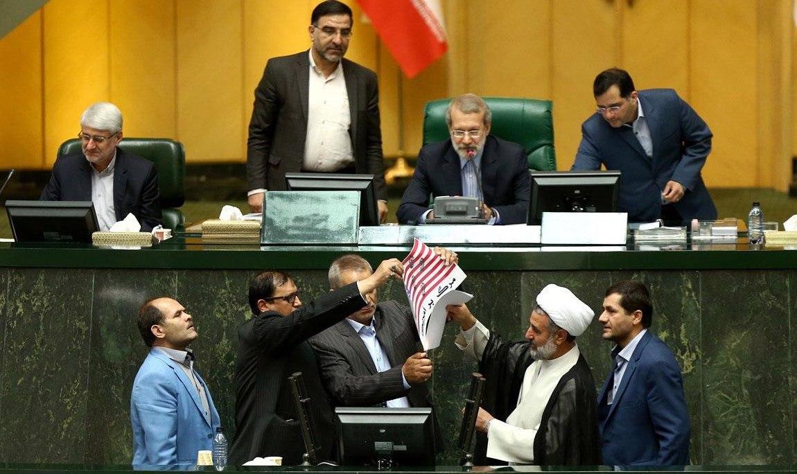 Un grupo de diputados iraníes queman una bandera de EE.UU. en protesta por la decisión del presidente estadounidense, Donald Trump, de retirarse del pacto nuclear, durante una sesión en el Parlamento en Teherán 
