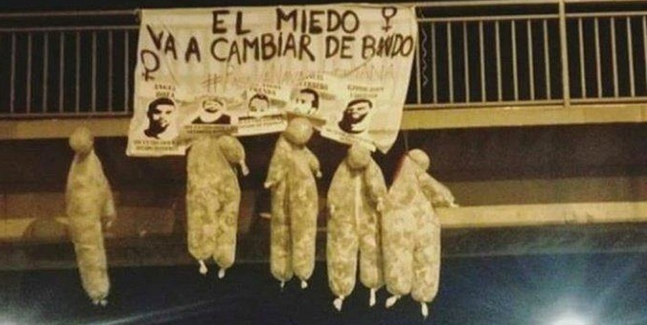 Muñecos emulando a La Manada colgando de un puente. 