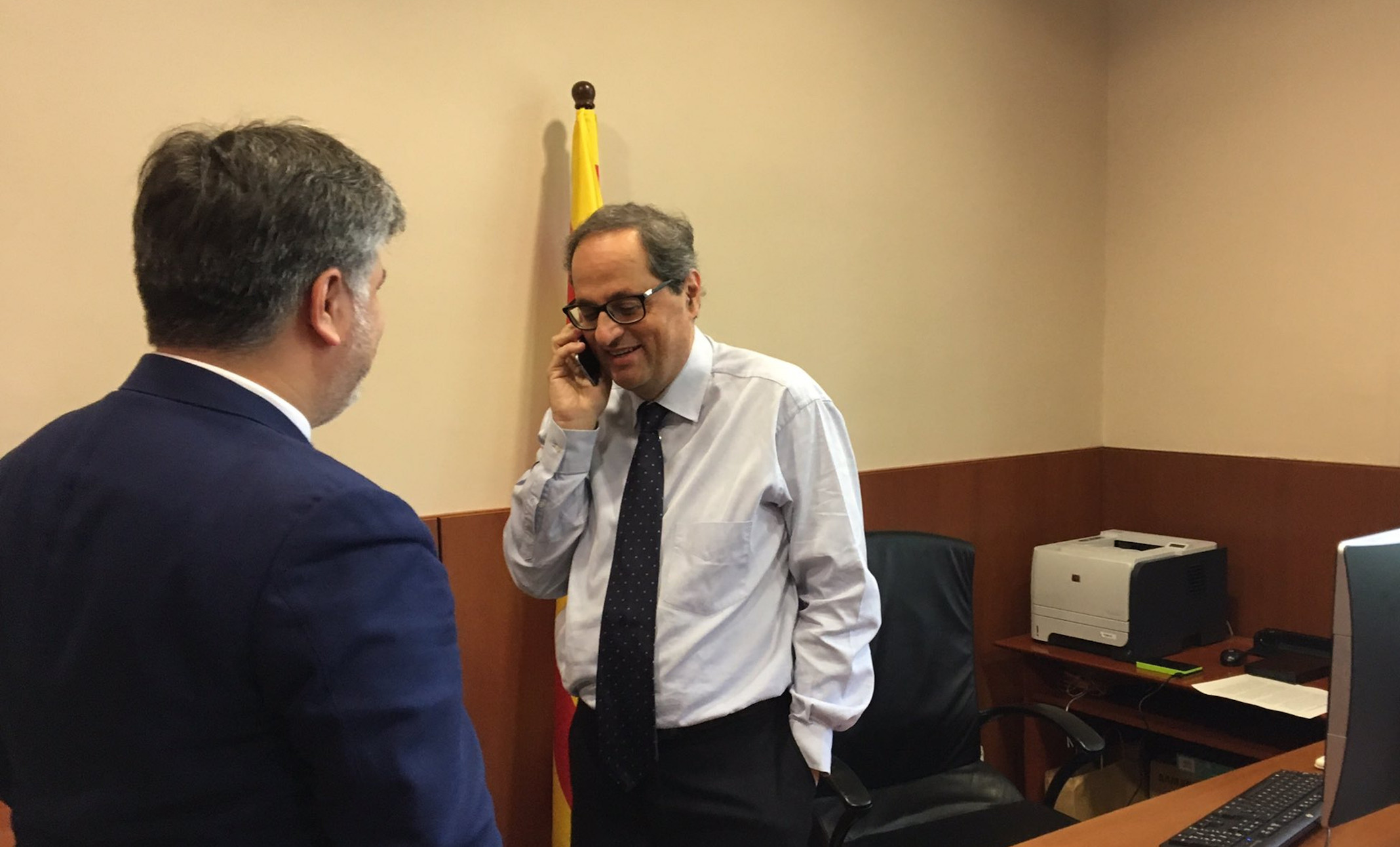 Quim Torra en el Parlament hablando por teléfono con Carles Puigdemont.