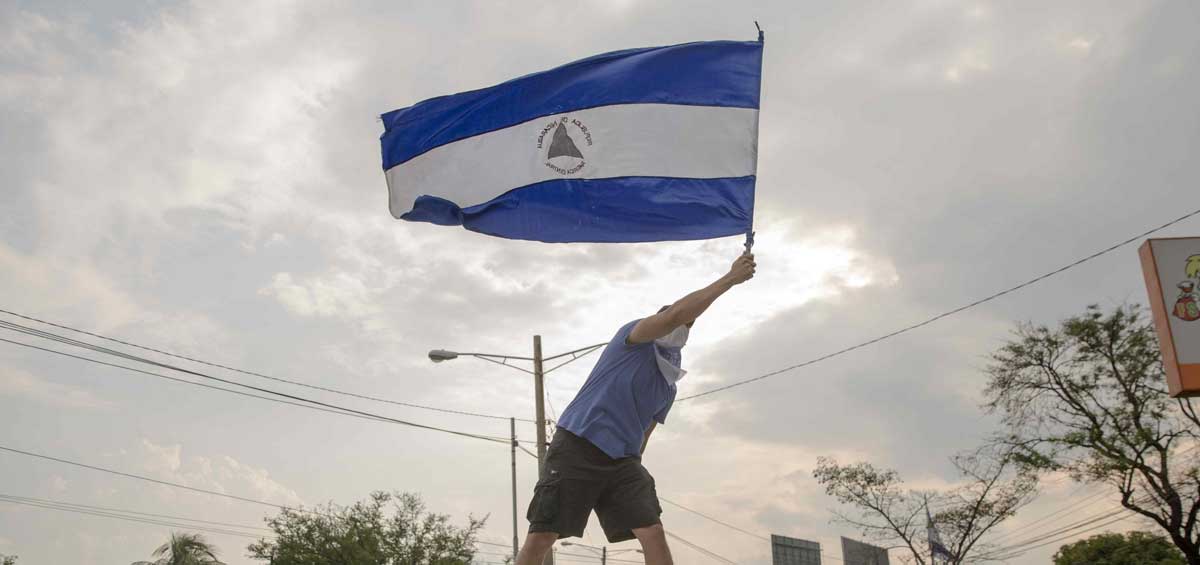 Un hombre levanta la bandera de Nicaragua durante una marcha nacional en contra del Gobierno de Daniel Ortega. 