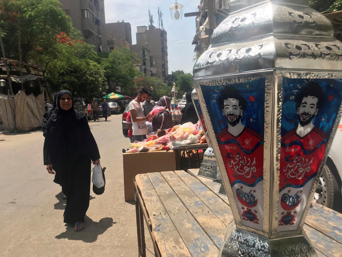 Una mujer observa un farol típico del mes sagrado de Ramadán que este año lucen el rostro del futbolista egipcio Mohamed Salah