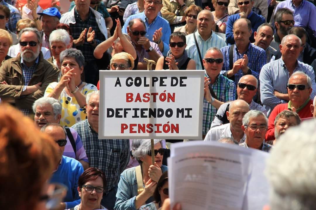 Una mujer portando una pancarta en una manifestación. 