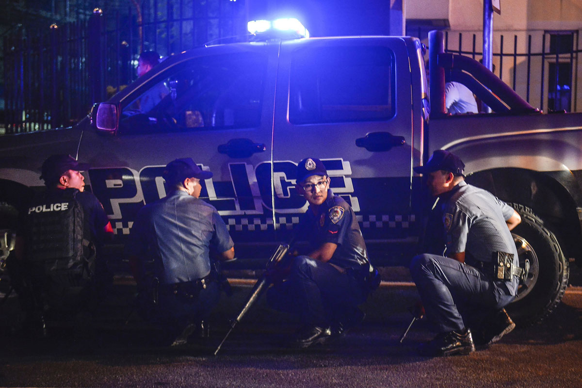 Varios policías filipinos toman posiciones en los alrededores del hotel Resort World Manila