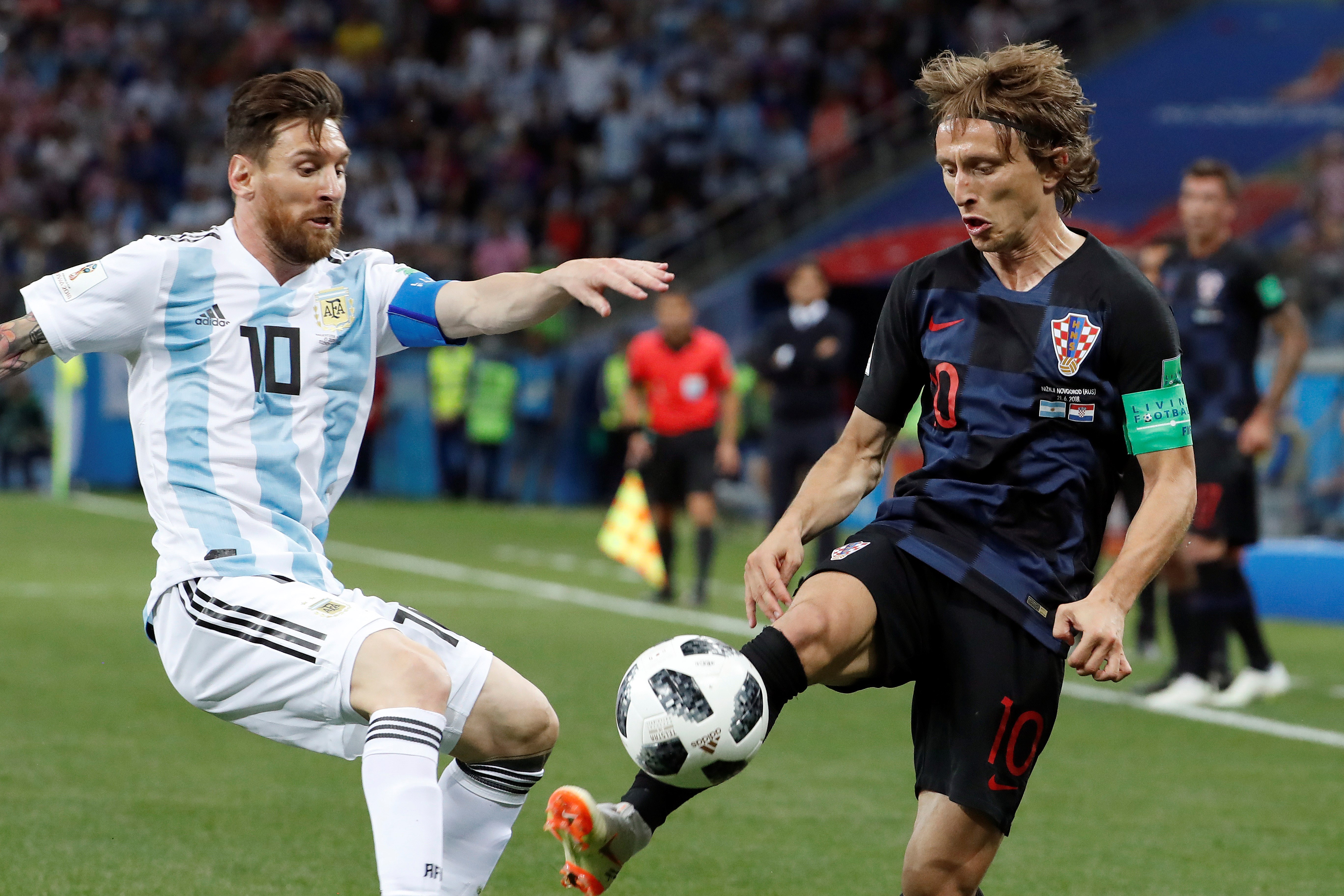 Lionel Messi (izquierda) y Luka Modric pelean por una pelota.