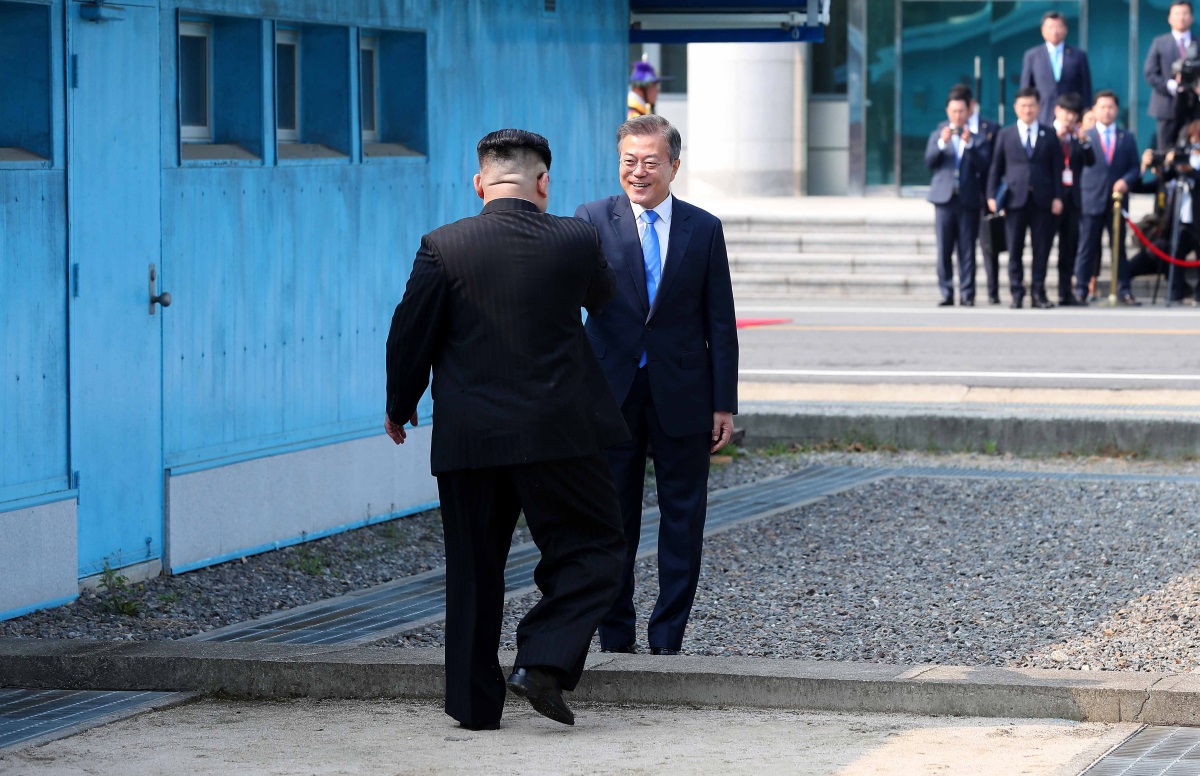 El presidente surcoreano Moon Jae-in (d) y el líder norcoreano Kim Jong-un (i) se dan la mano en la línea de demarcación militar (MDL)