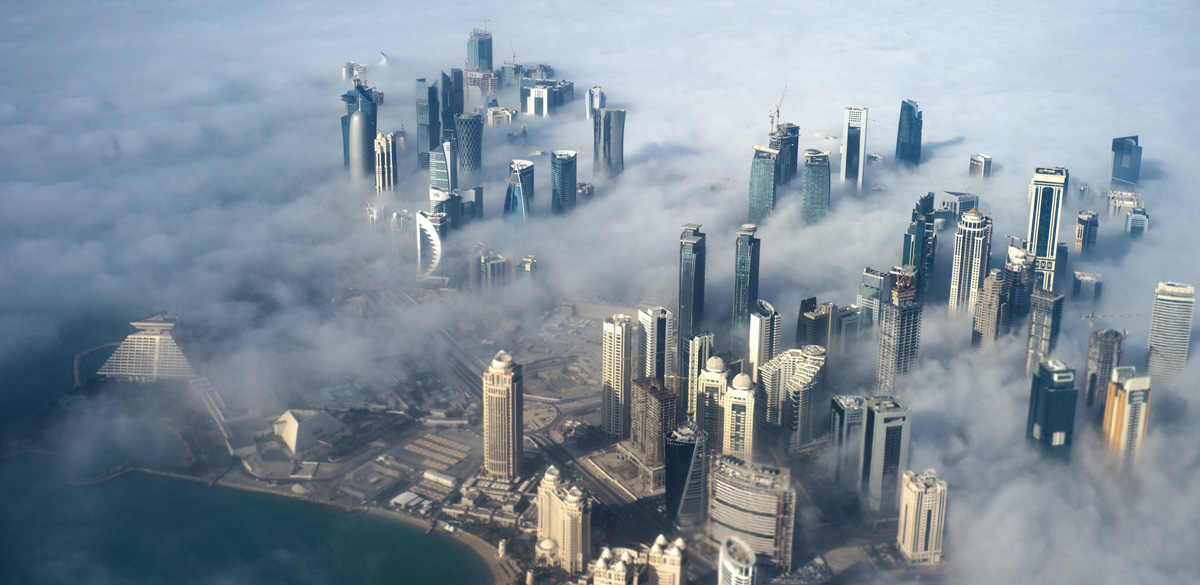 Una vista aérea de los rascacielos que emergen a través de la niebla que cubre el horizonte de Doha, Catar