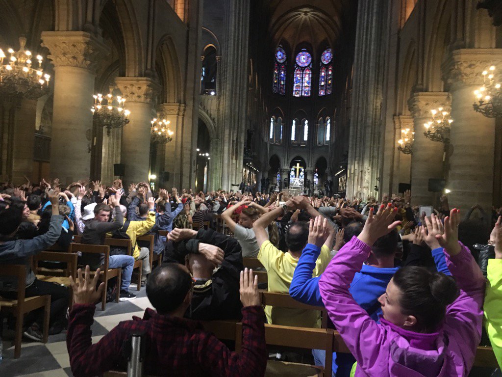 Turistas y visitantes de la catedral de Notre Dame esperan las indicaciones de la polícía