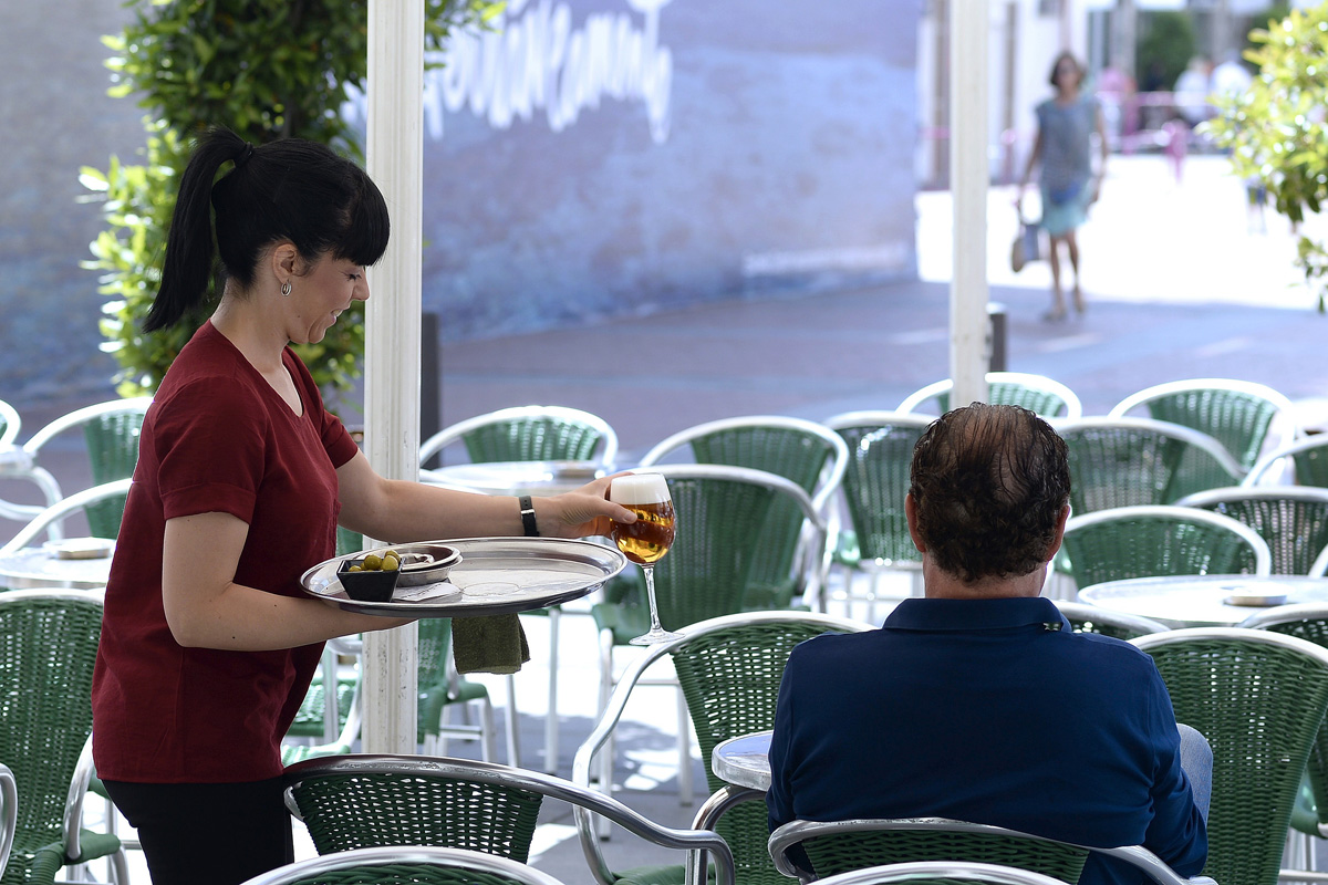 Una camarera sirve una consumición en una terraza de Valladolid