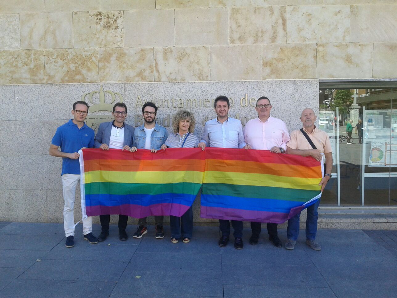 Miembros de la oposición de Boadilla, con un representante de Arcópoli, despliegan una bandera arcoíris en la fachada del Consistorio