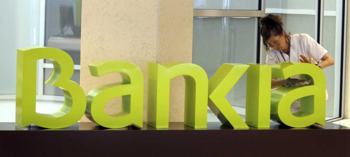 Una operaria limpia el logo de Bankia. EFE/Archivo