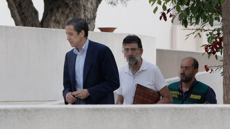 El expresidente de la Generalitat Valenciana y exministro de Trabajo, Eduardo Zaplana (i), a su llegada a su chalé de Benidorm (Alicante) acompañado por agentes de la UCO de la Guardia Civil. EFE