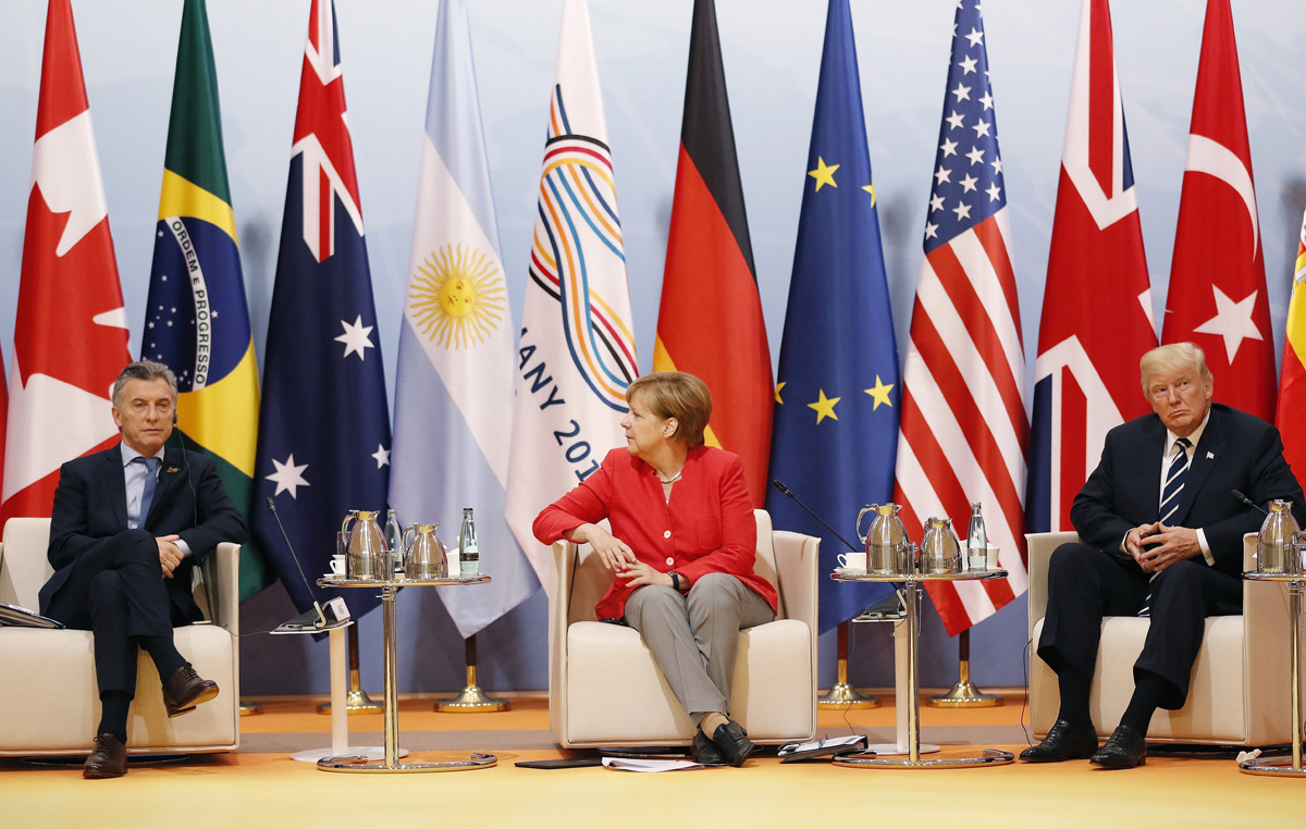 La canciller alemana, Angela Merkel (c), conversa con el presidente estadounidense, Donald J. Trump (dcha), y con el mandatario argentino, Mauricio Macri (izq)