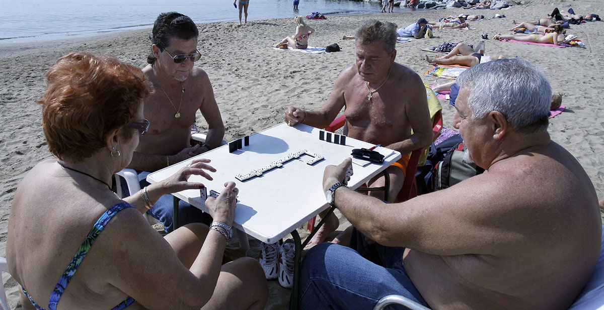 Jubilados jugando al dominó en la playa