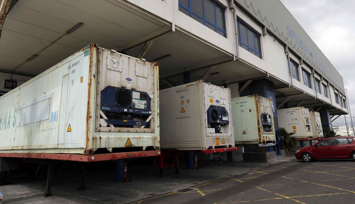 Varios contenedores estacionados en el muelle de un puerto.