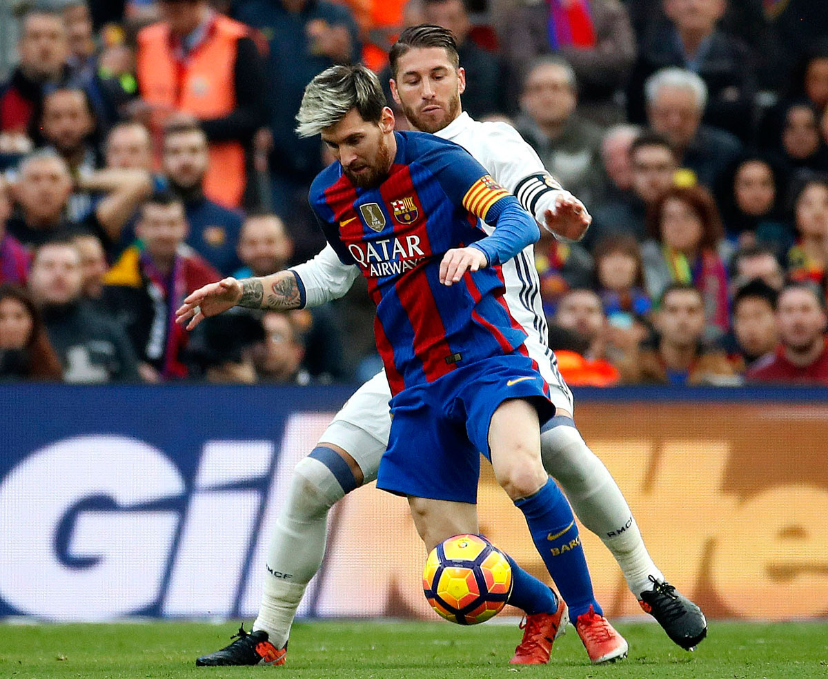 El defensa del Real Madrid Sergio Ramos (d) presiona al delantero del Barcelona Leo Messi.