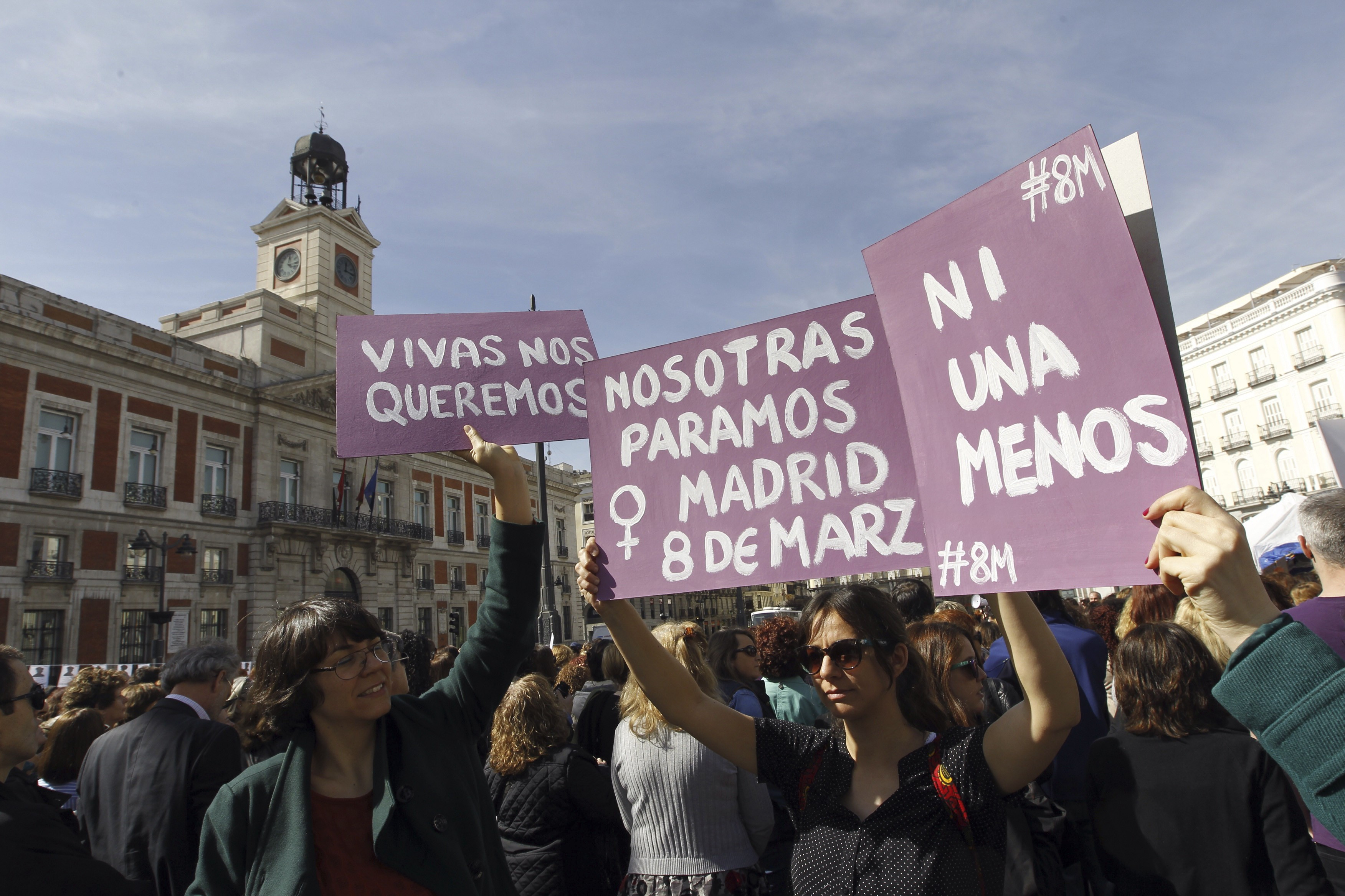 Tres personas alzan carteles para denunciar la violencia machista con motivo del Día Internacional de la Mujer en la madrileña Puerta del Sol. en 2019