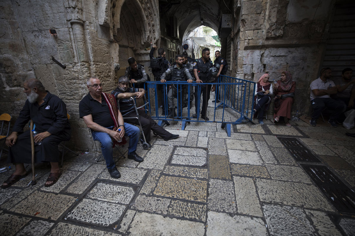 Varios palestinos esperan fuera de la Puerta de los Leones, el acceso principal al complejo en el que se encuentra la Mezquita de Al Aqsa en Jerusalén (Israel).