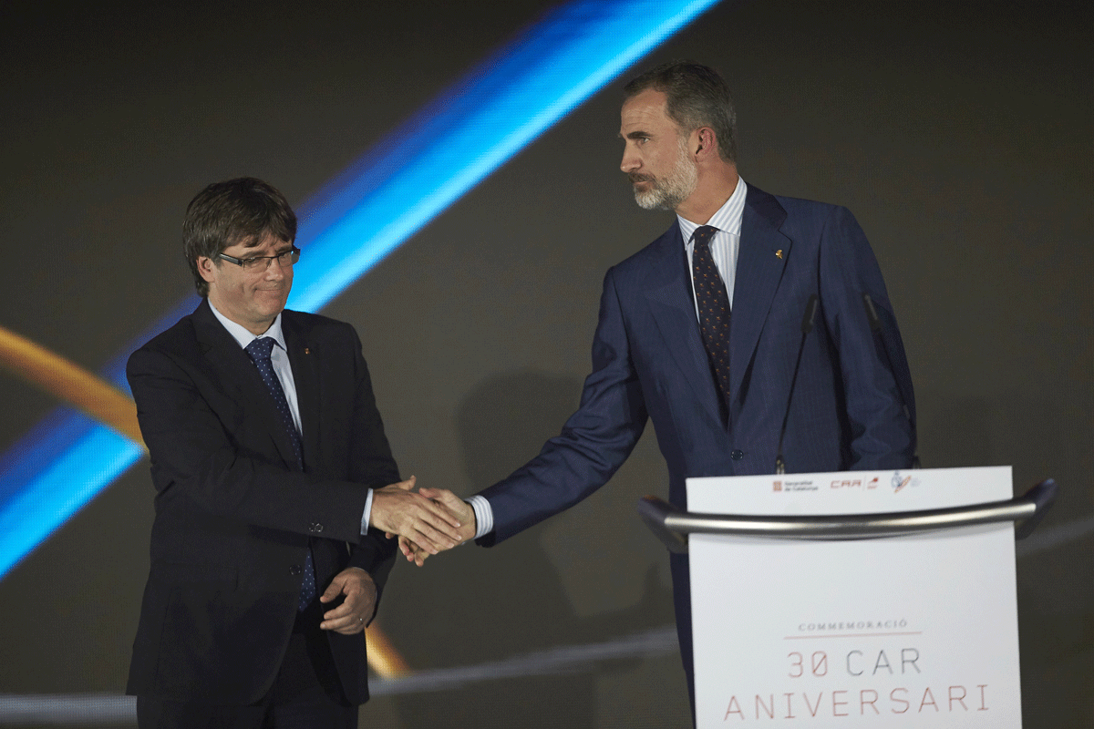 El rey Felipe VI y el presidente de la Generalitat, Carles Puigdemont, se dan la mano en la celebración de 25 aniversario de BARCELONA 92.