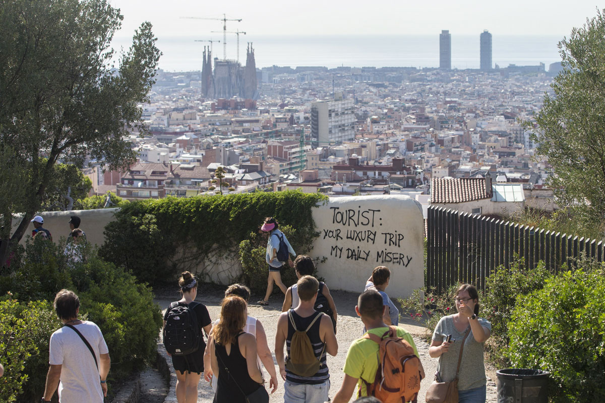 Un grupo de turistas pasea por los alrededores del Parque Güell de Barcelona , donde últimamente han aparecido pintadas contrarias al turismo masificado.