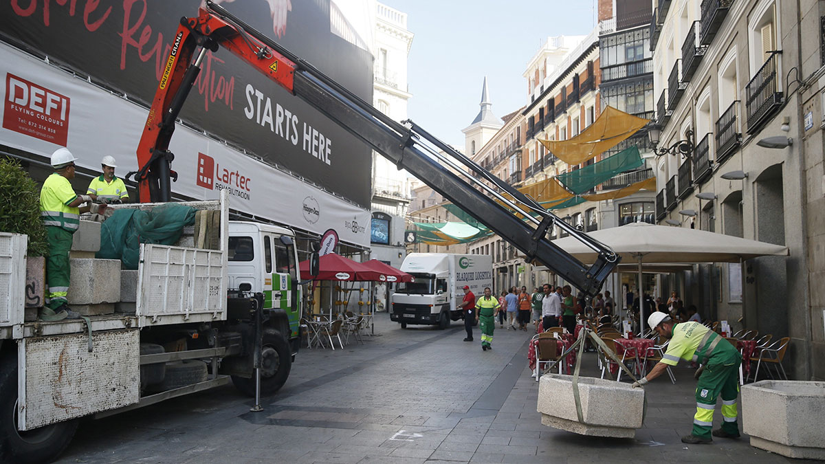 Operarios del Ayuntamiento de Madrid colocan jardineras esta mañana en la céntrica Calle del Carmen