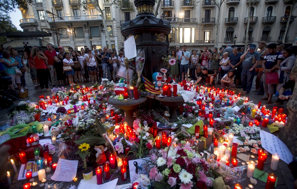 Flores y velas recuerdan en la fuente de Canaletas, en las Ramblas, a las víctimas del atentado. 