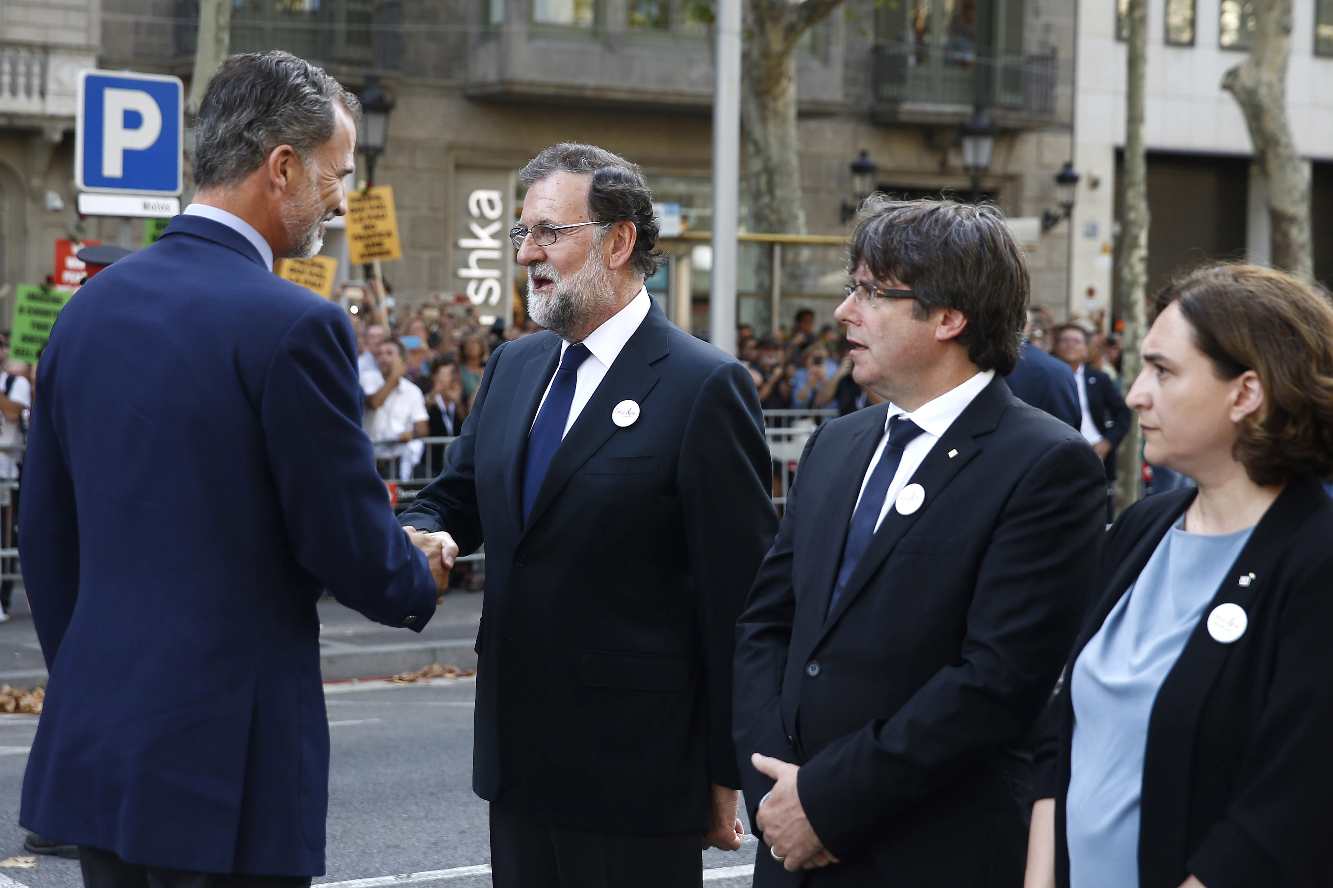 El rey Felipe saluda al presidente del Gobierno, Mariano Rajoy, ante Carles Puigdemont y Ada Colau. 