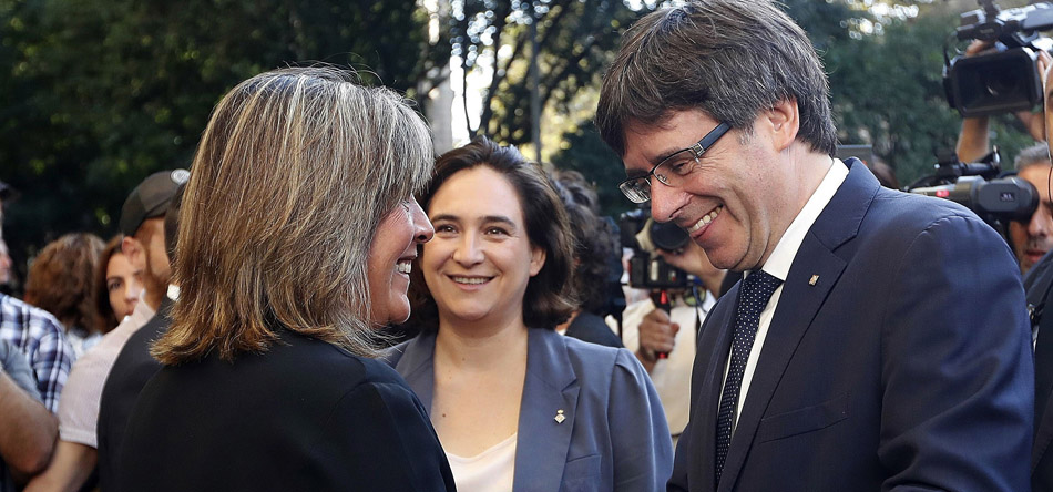 El presidente de la Generalitat, Carles Puigdemont, conversa con Ada Colau y la alcaldesa de L'Hospitalet de Llobregat, Núria Marín, al inicio de la ofrenda floral