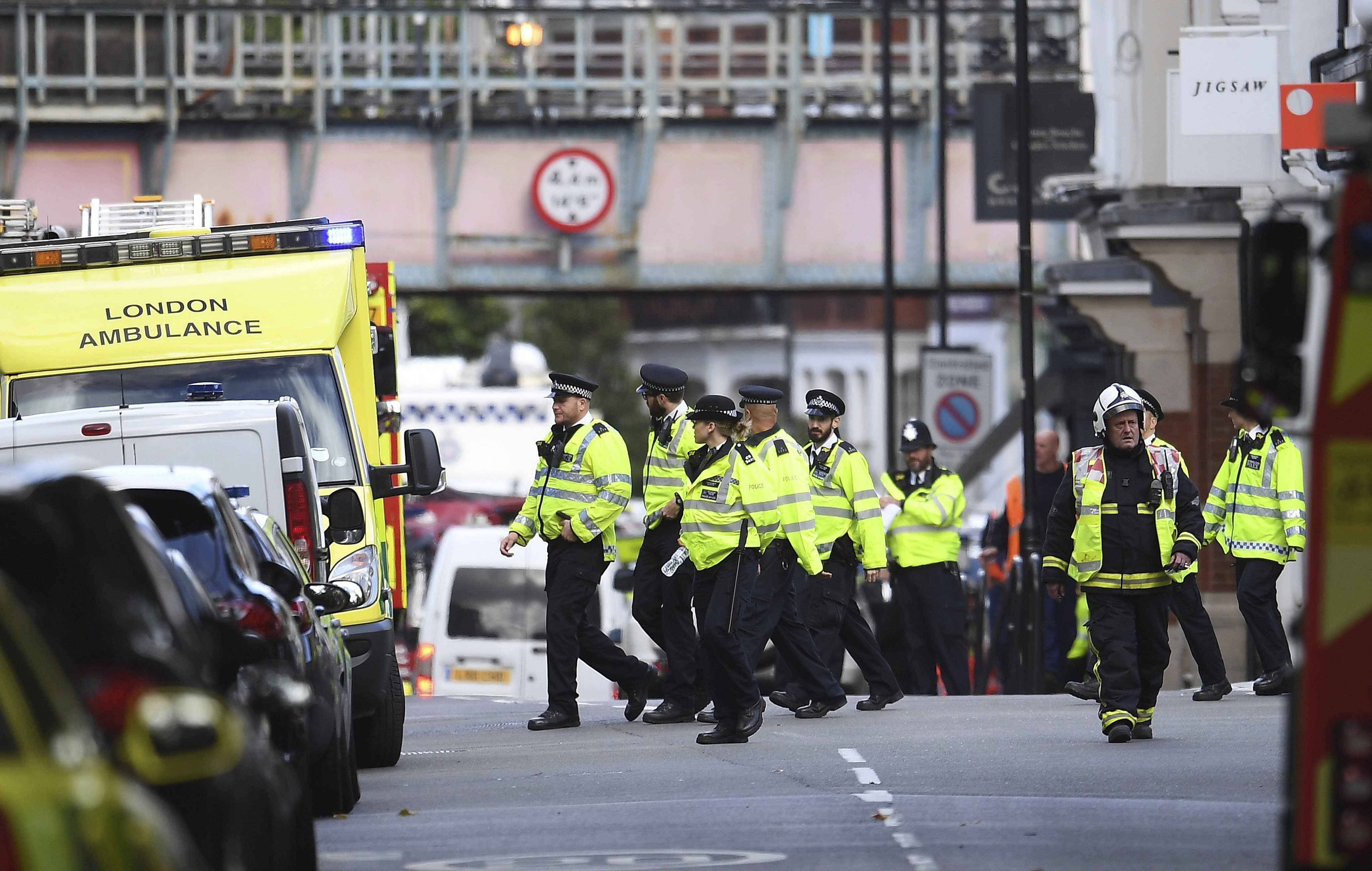 Bomberos y policías caminan junto a la estación de metro Parsons Green en Londres. 