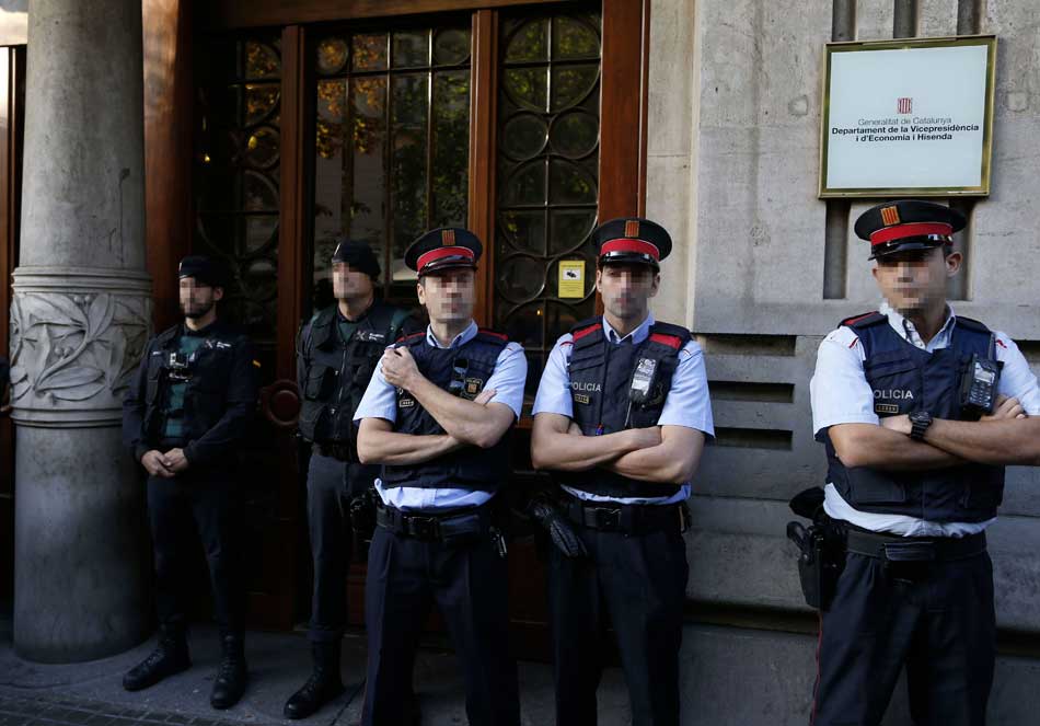 Agentes de la Guardia Civil y de los Mossos d'Esquadra en la puerta de la consellería de Economía de la Generalitat. EFE