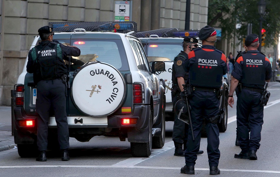 Mossos d'esquadra escoltan a los vehículos de la Guardia Civil durante un registro el pasado miércoles en la sede de la consellería de Exteriores.