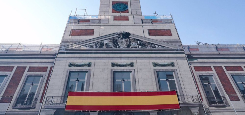 Bandera española en la sede del Gobierno madrileño, en Sol