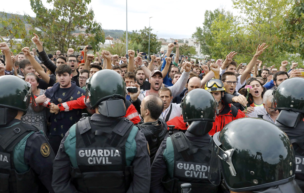 La Guardia Civil frente a bomberos y manifestantes independentistas en Cataluña durante el 1-O - EFE