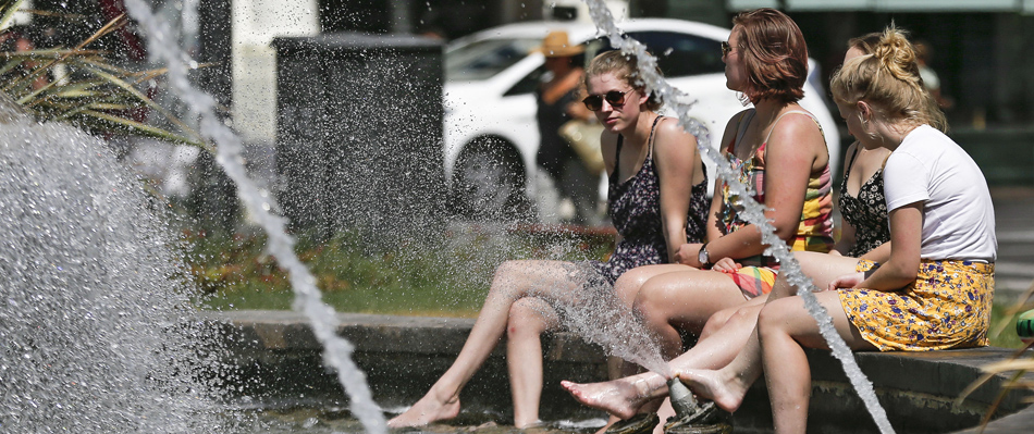Unas turistas se refrescan en la fuente de la plaza del Ayuntamiento de Valencia