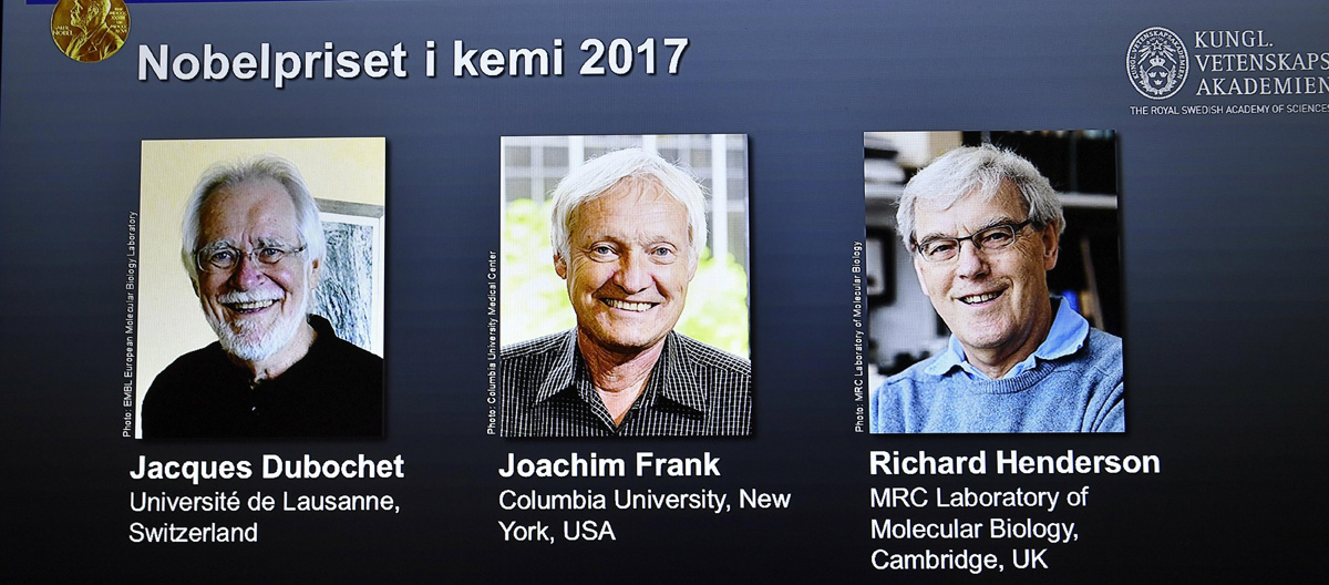 Una pantalla muestra a los tres ganadores del Premio Nobel de Química 2017