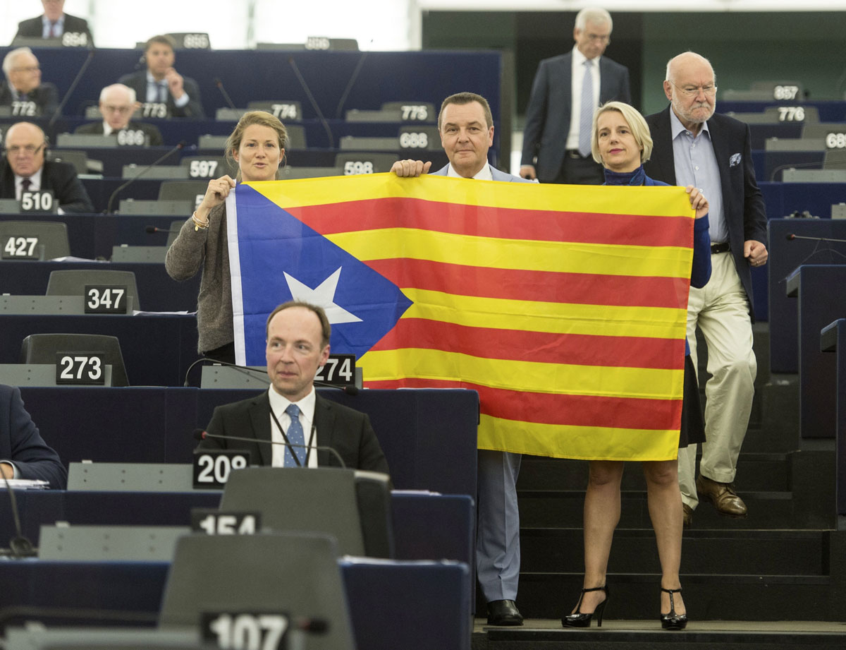 Eurodiputados posan con una bandera estelada durante el debate sobre Cataluña