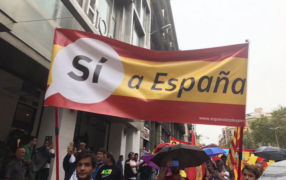 Un grupo de personas portando banderas de España. 